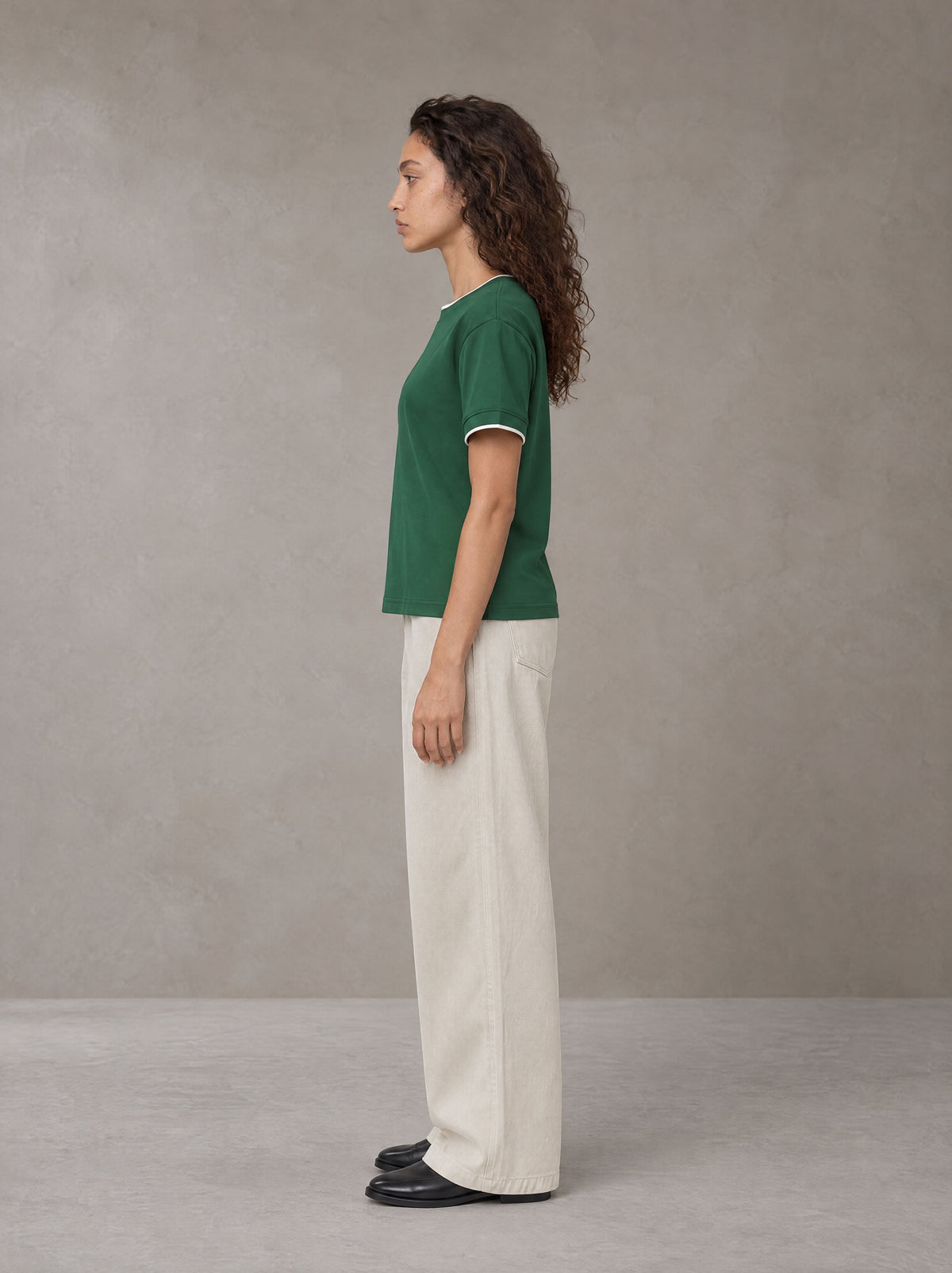 Model wearing SM Straight Leg Trousers in Oat Grey, side view.