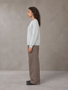 Model wearing SM Straight Leg Trousers in Kabul Brown, side view.