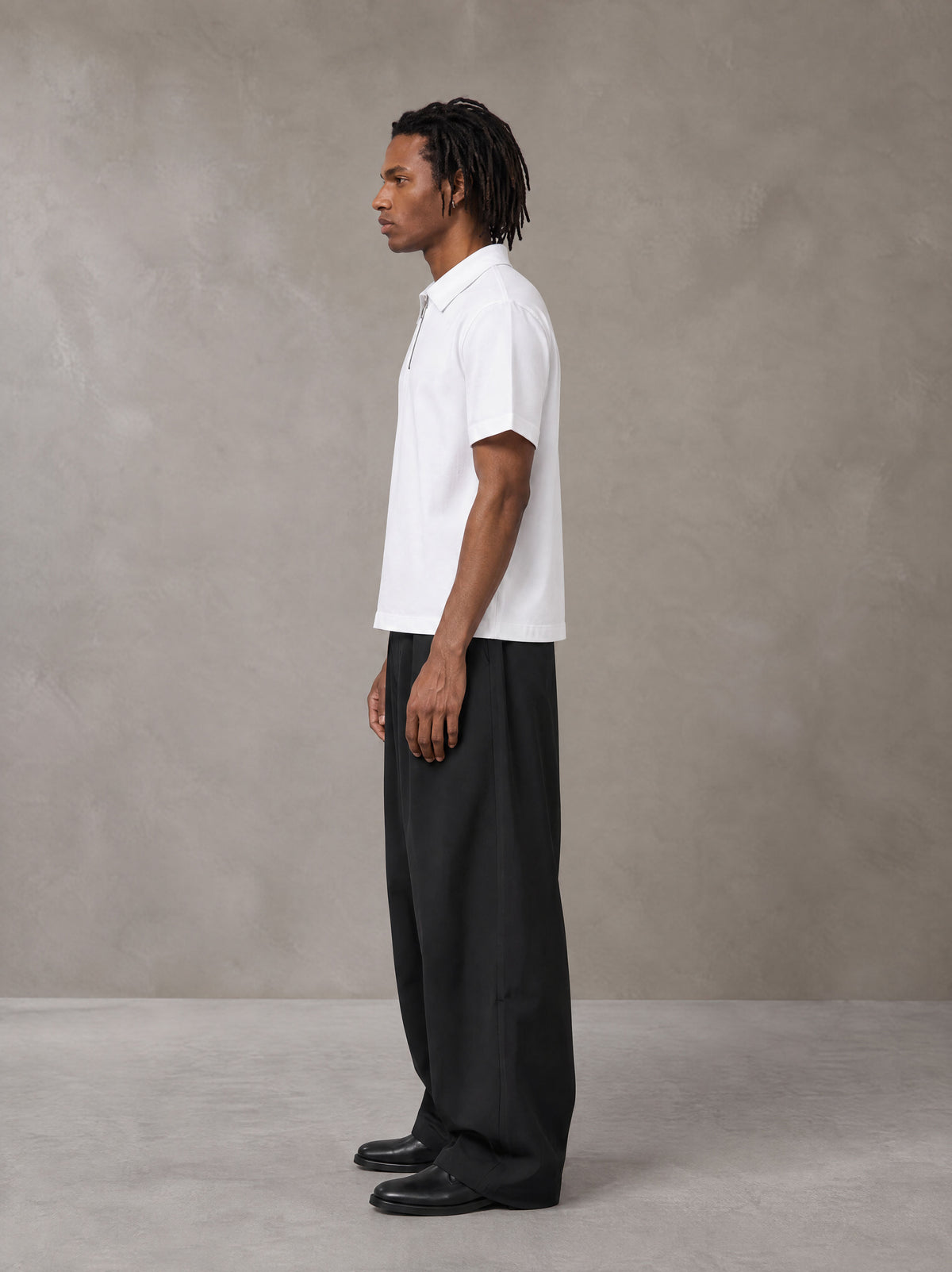 Model wearing SM Curved Trousers in Midnight Black, side view.