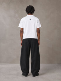 Model wearing SM Curved Trousers in Midnight Black, rear view.