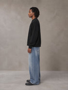 Model wearing SM Sig. Knitted Round Neck Sweatshirt in Midnight Black, side view.