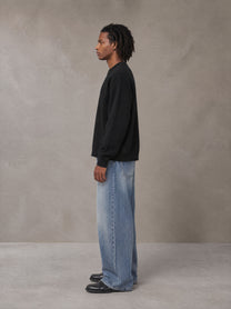 Model wearing SM Sig. Knitted Round Neck Sweatshirt in Midnight Black, side view.