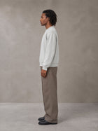 Model wearing SM Sig. Knitted Round Neck Sweatshirt in Solitude, side view.