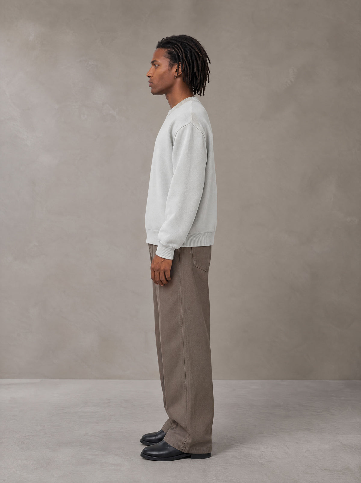Model wearing SM Sig. Knitted Round Neck Sweatshirt in Solitude, side view.