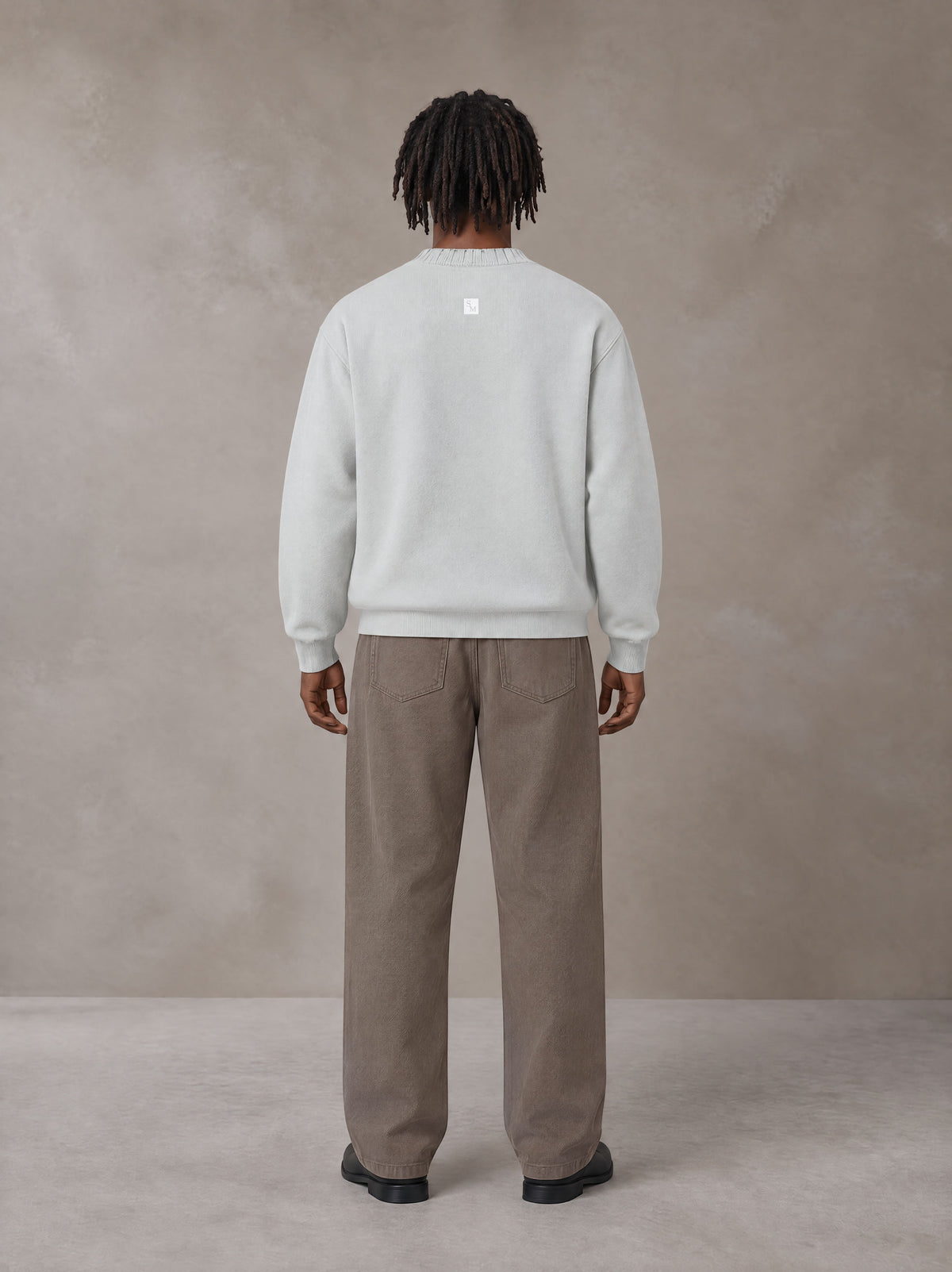 Model wearing SM Sig. Knitted Round Neck Sweatshirt in Solitude, rear view.