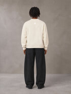 Model wearing SM Sig. Knitted Round Neck Sweatshirt in Neutral Heather, rear view.