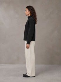 Model wearing SM Sig. Half-Zip Fleece Sweatshirt in Midnight Black, side view.