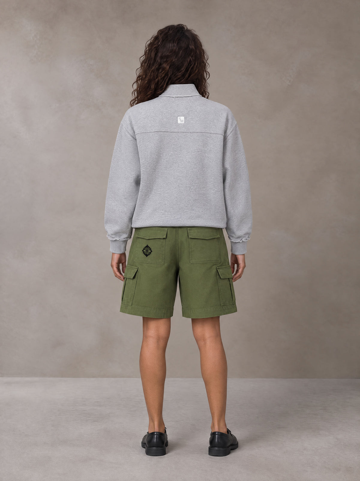 Model wearing SM Sig. Half-Zip Fleece Sweatshirt in Floral Grey, rear view.