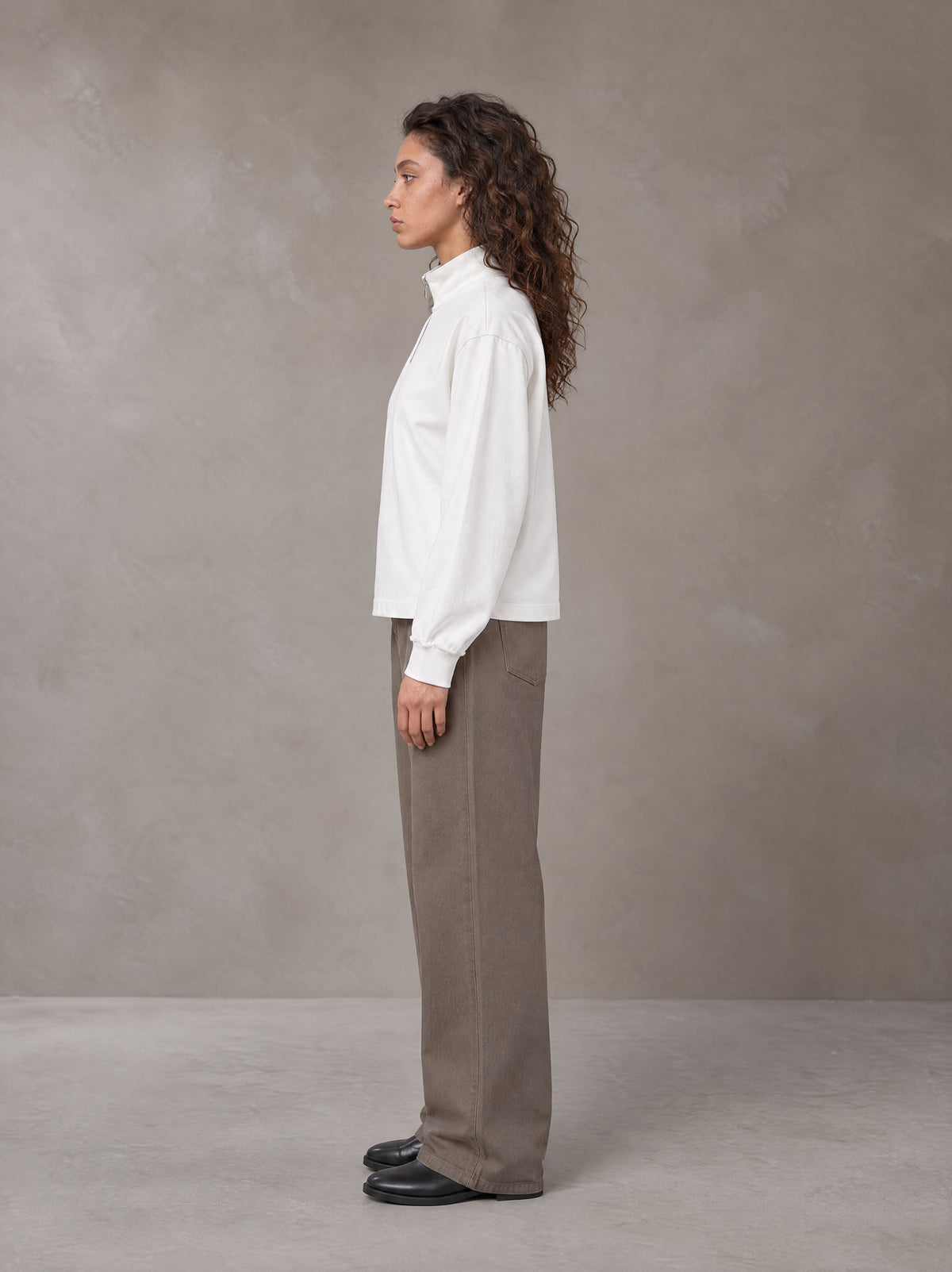 Model wearing SM Sig. Half-Zip Fleece Sweatshirt in Lucent White, side view.