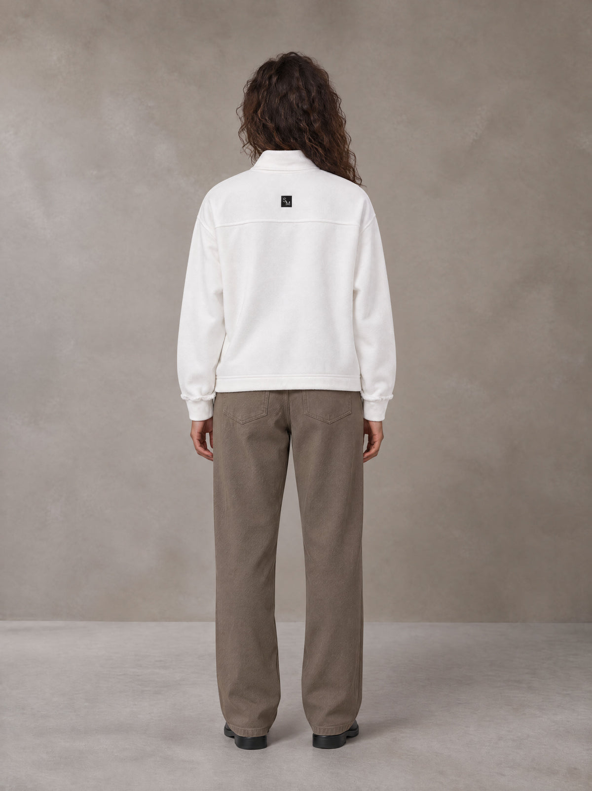 Model wearing SM Sig. Half-Zip Fleece Sweatshirt in Lucent White, rear view.