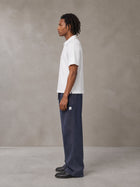 Model wearing SM Sig. Sun Fade Sweatpants in Oxford Navy, side view.