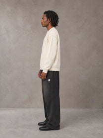 Model wearing SM Sig. Sun Fade Sweatpants in Midnight Black, side view.