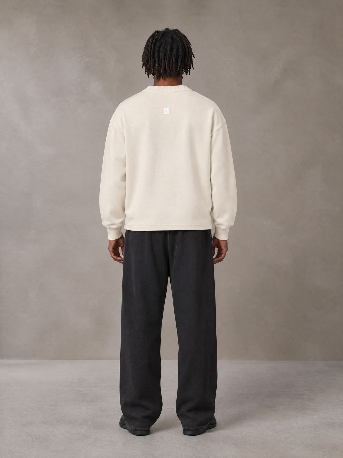 Model wearing SM Sig. Sun Fade Sweatpants in Midnight Black, rear view.