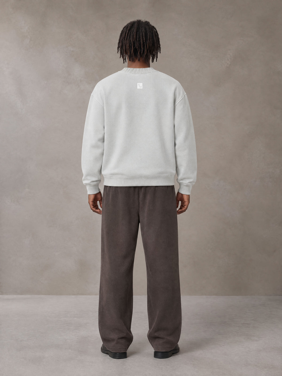 Model wearing SM Sig. Sun Fade Sweatpants in Kabul Brown, rear view.