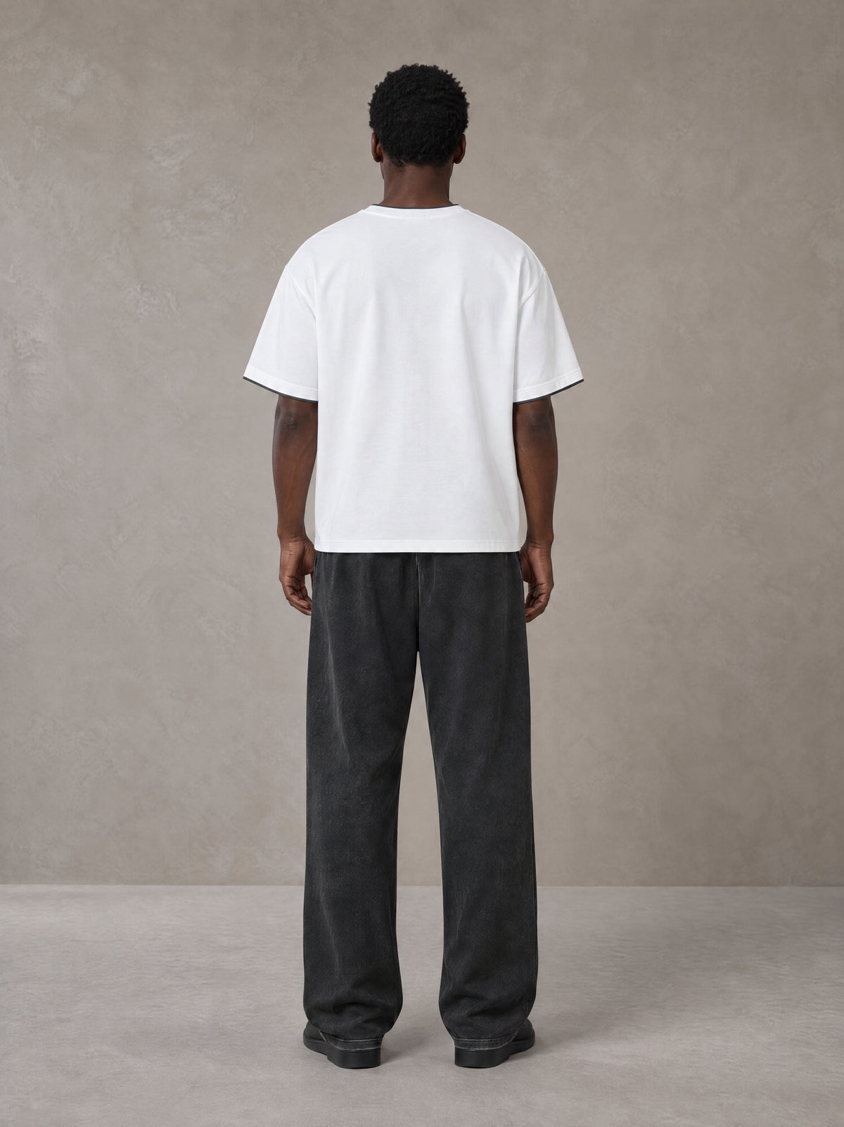 Model wearing SM Snow Fade Sweatpants in Midnight Black, rear view.