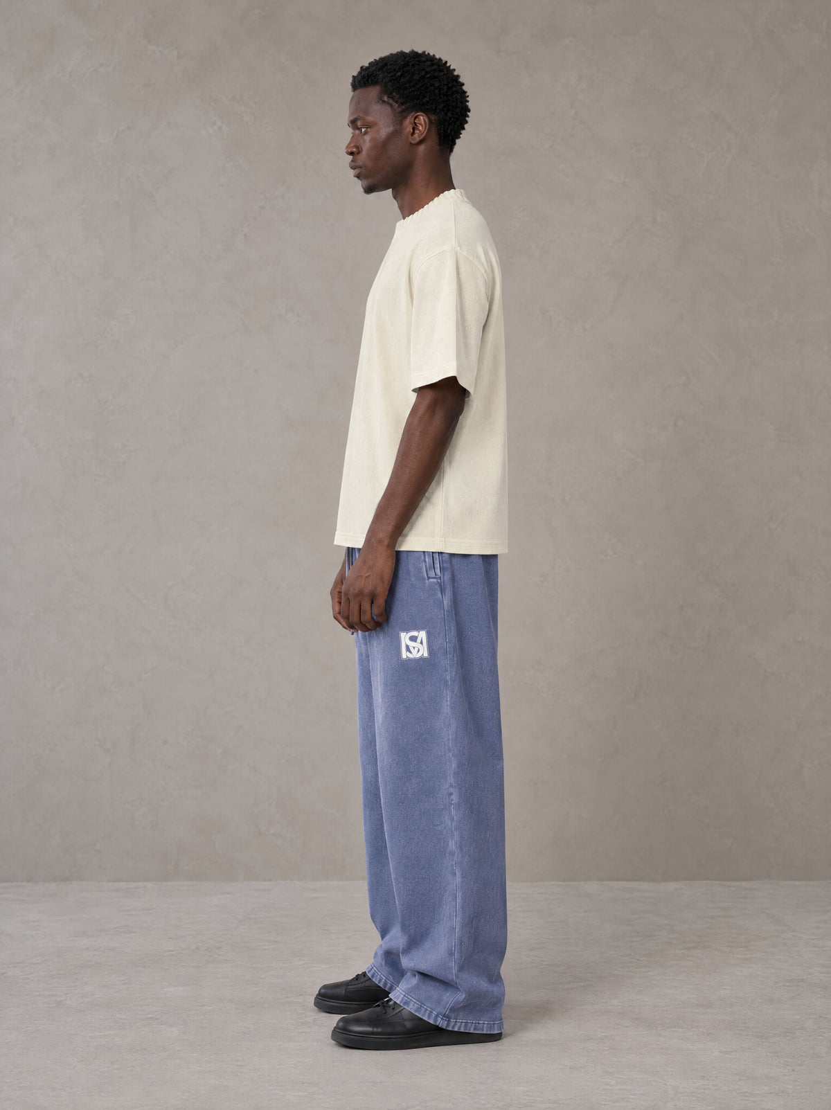 Model wearing SM Snow Fade Sweatpants in Chambray, side view.