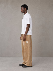 Model wearing SM Snow Fade Sweatpants in Aged Whiskey, side view.