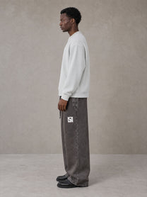 Model wearing SM Snow Fade Sweatpants in Graphite, side view.