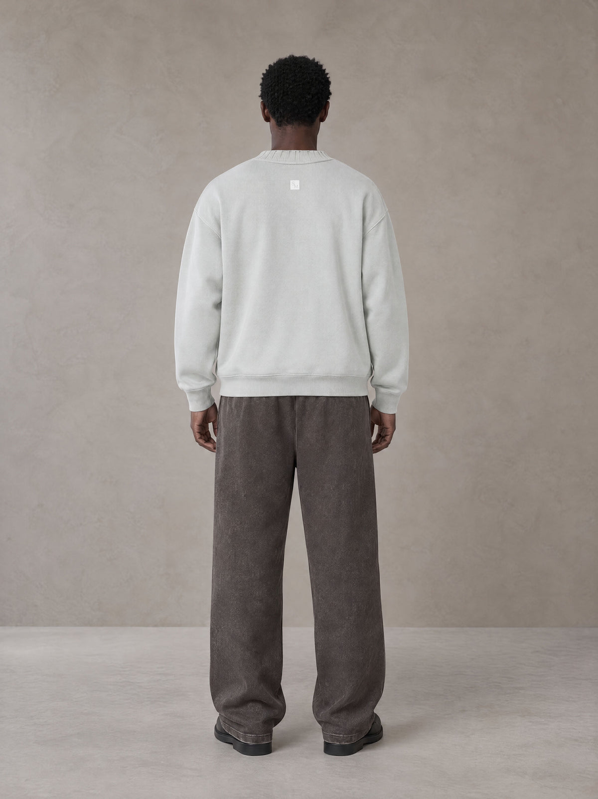 Model wearing SM Snow Fade Sweatpants in Graphite, rear view.