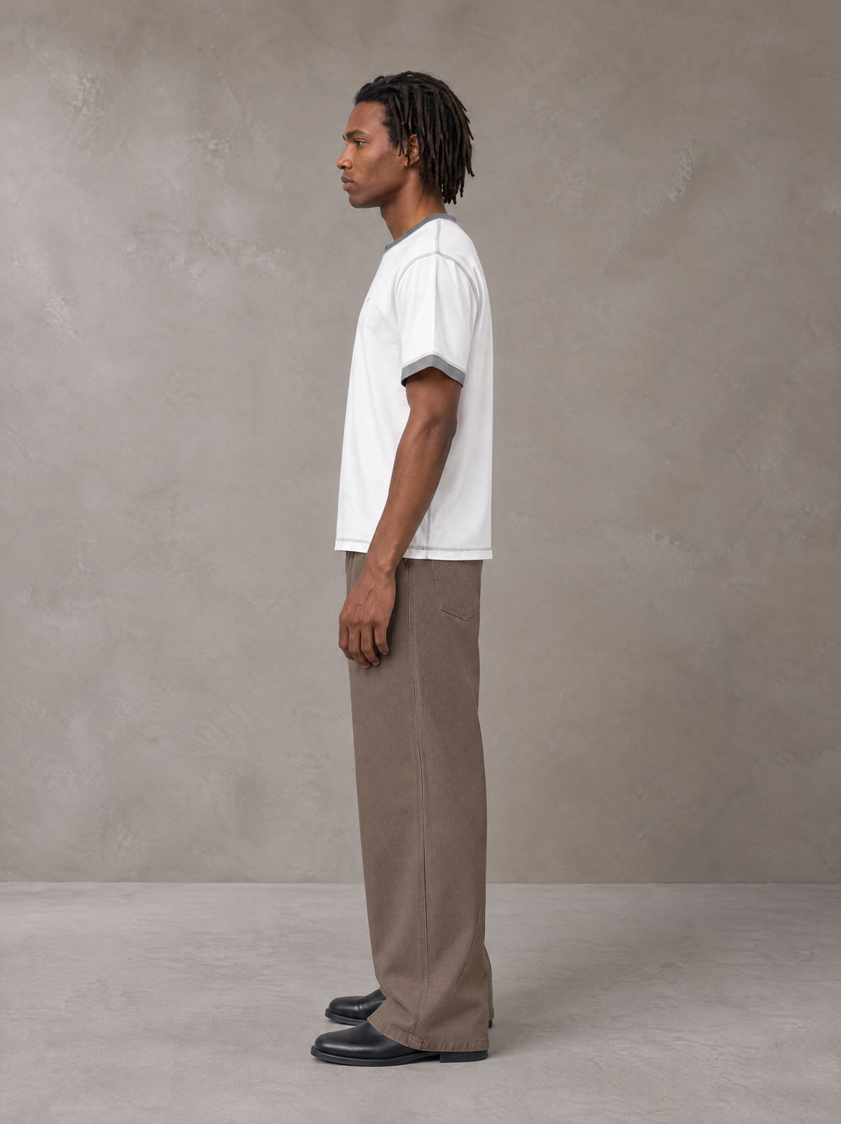 Model wearing SM Sig. Contrast Stitch T-shirt in Lucent White, side view.