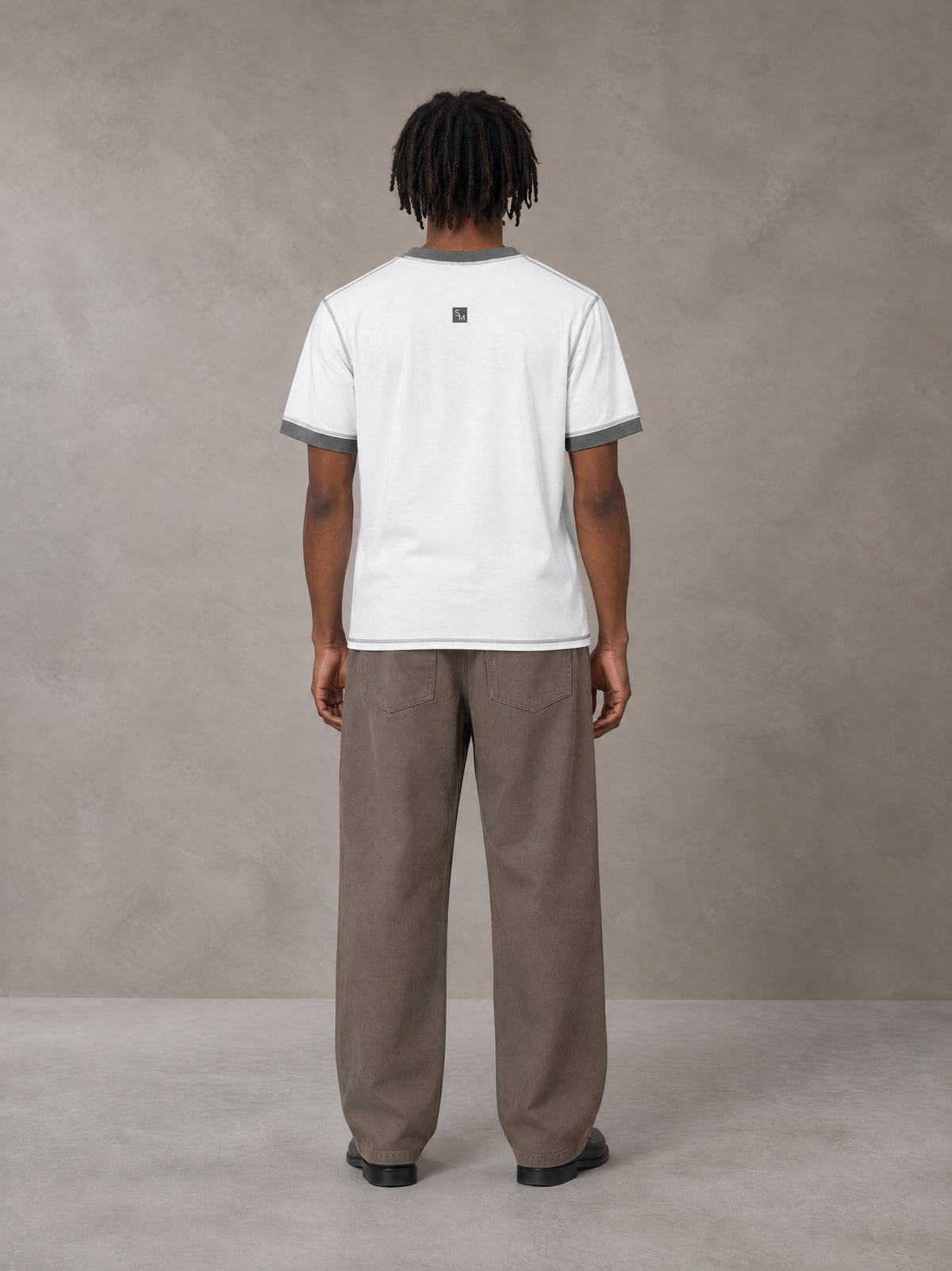 Model wearing SM Sig. Contrast Stitch T-shirt in Lucent White, rear view.