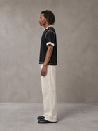 Model wearing SM Sig. Contrast Stitch T-shirt in Midnight Black, side view.