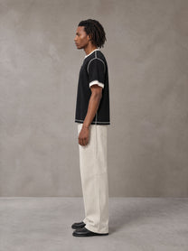 Model wearing SM Sig. Contrast Stitch T-shirt in Midnight Black, side view.