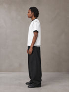 Model wearing SM Sig. Contrast Stitch T-shirt in Lucent White, side view.