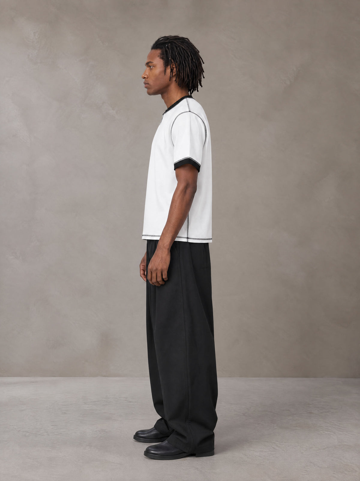 Model wearing SM Sig. Contrast Stitch T-shirt in Lucent White, side view.