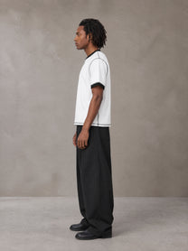 Model wearing SM Sig. Contrast Stitch T-shirt in Lucent White, side view.