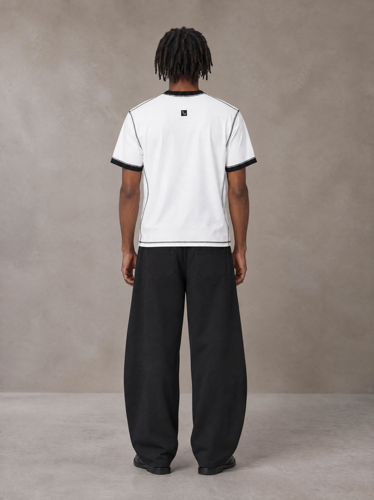Model wearing SM Sig. Contrast Stitch T-shirt in Lucent White, rear view.