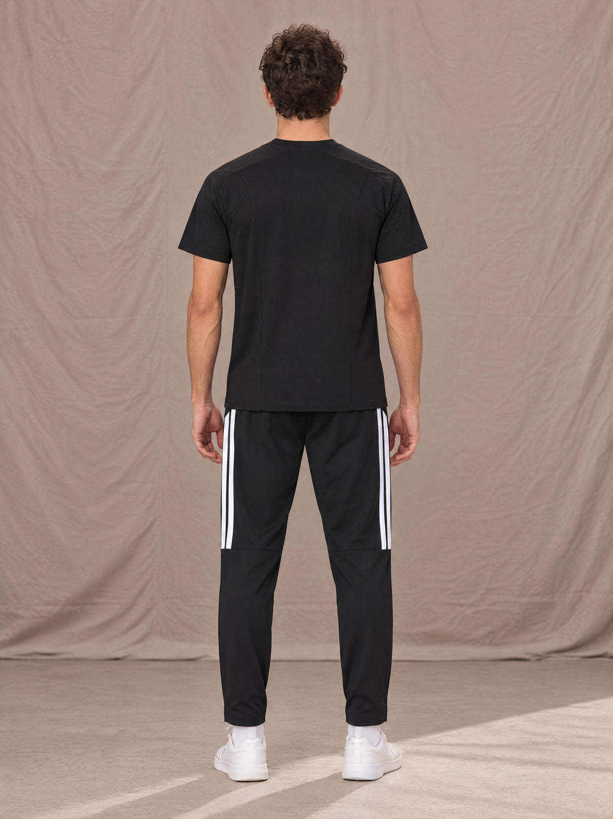 Model wearing SM Motion Stripe Track Trousers in Midnight Black, rear view.