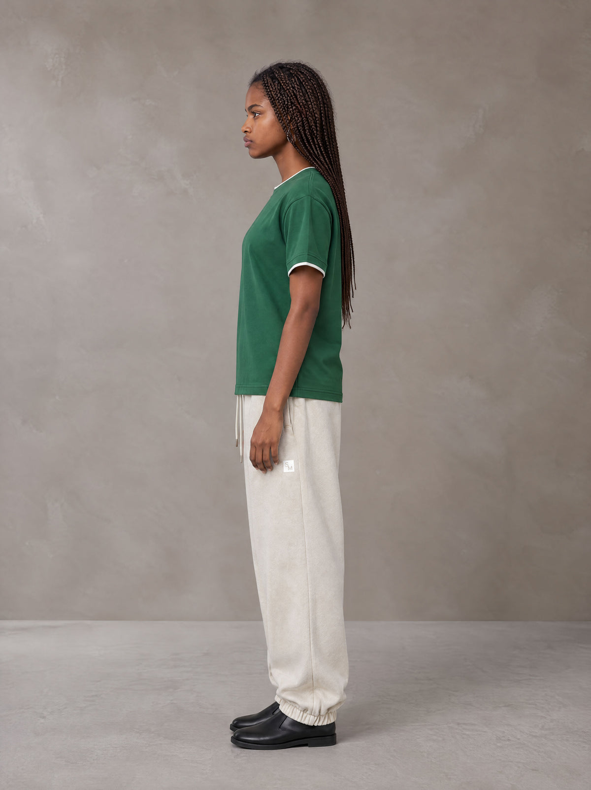 Model wearing SM Sig. Jogger Sweatpants in Oat Grey, side view.