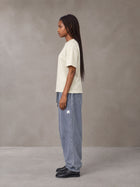 Model wearing SM Sig. Jogger Sweatpants in Washed Blue Jean, side view.