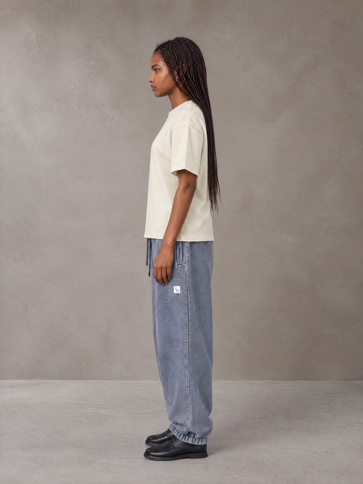 Model wearing SM Sig. Jogger Sweatpants in Washed Blue Jean, side view.