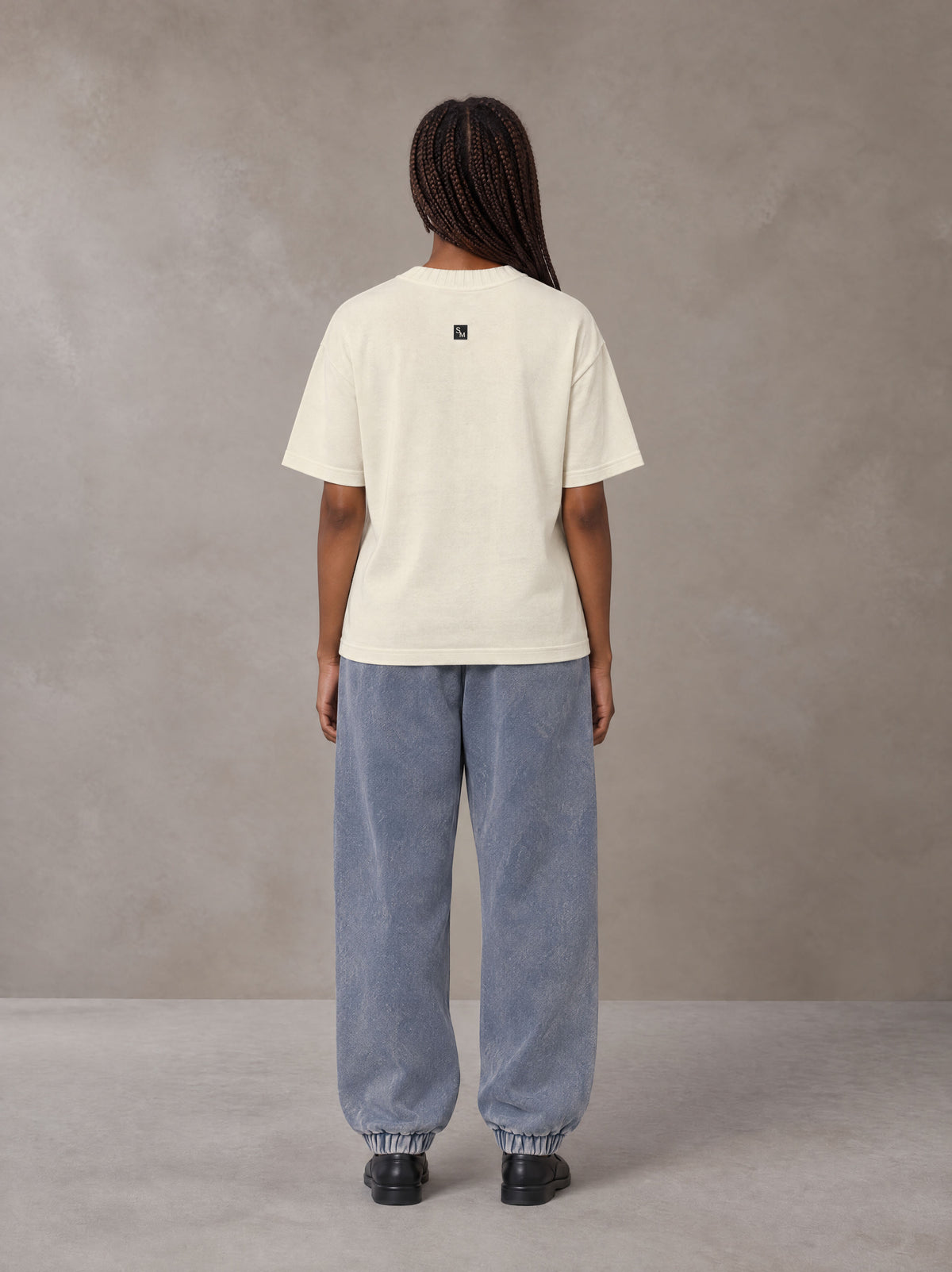 Model wearing SM Sig. Jogger Sweatpants in Washed Blue Jean, rear view.