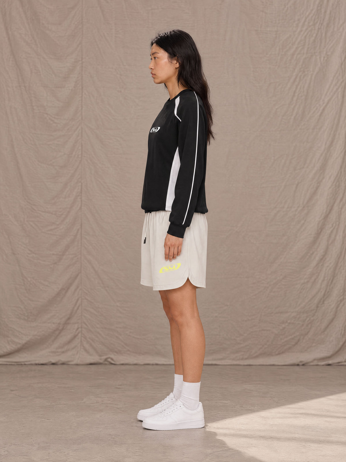 Model wearing SM Motion Sweatshirt in Midnight Black, side view.