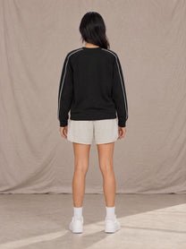 Model wearing SM Motion Sweatshirt in Midnight Black, rear view.