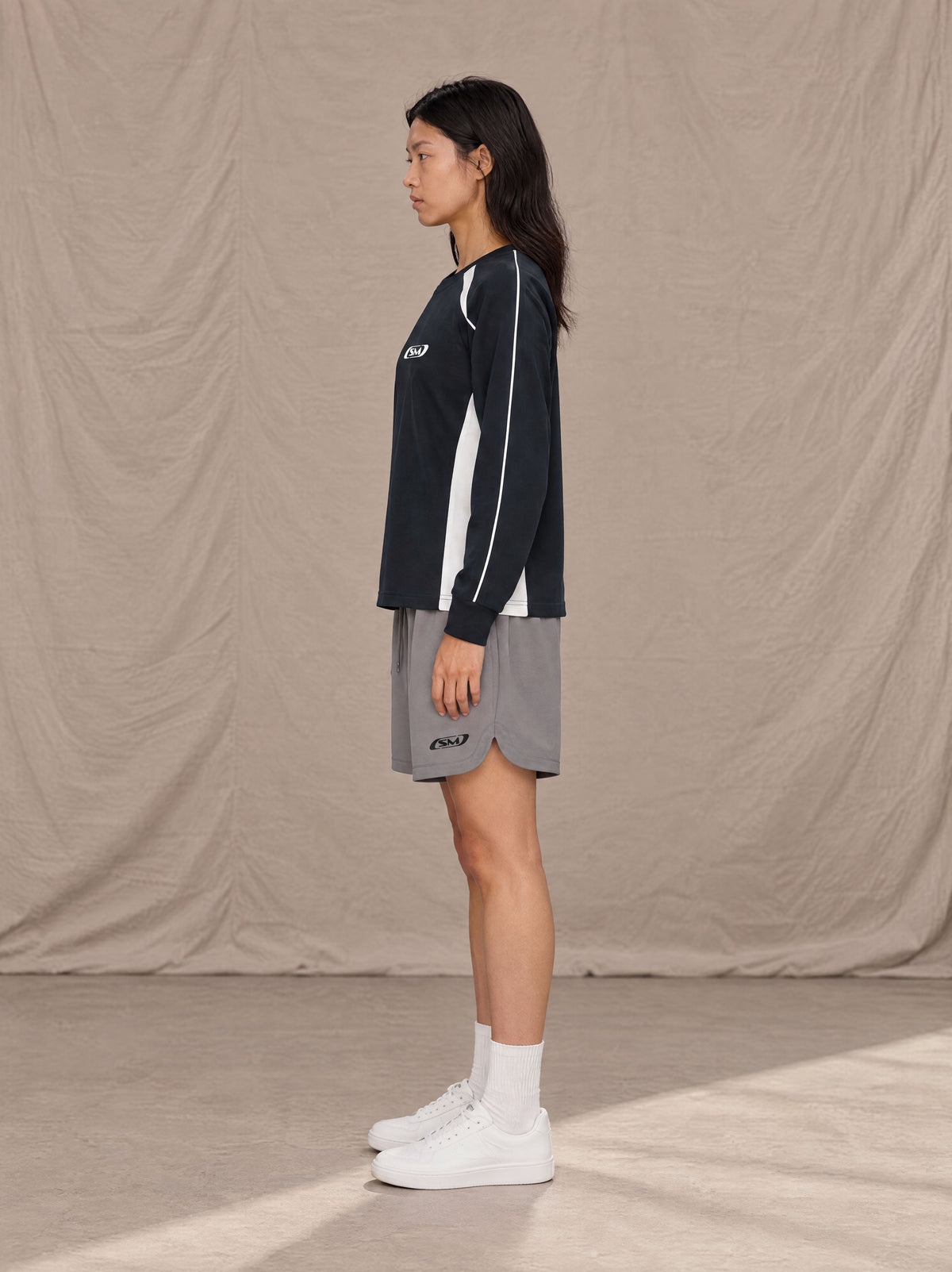 Model wearing SM Motion Sweatshirt in Oxford Navy, side view.