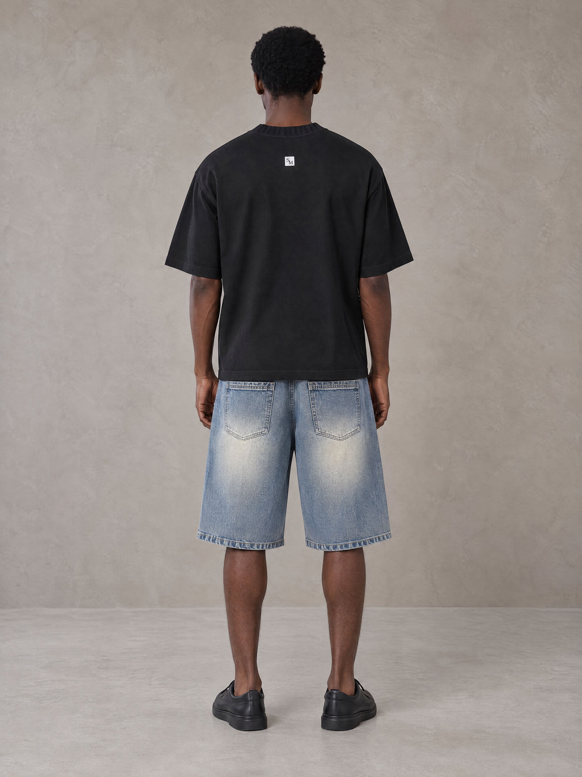 Model wearing SM Heritage Vintage Wash Denim Shorts in Cadet Grey, rear view.