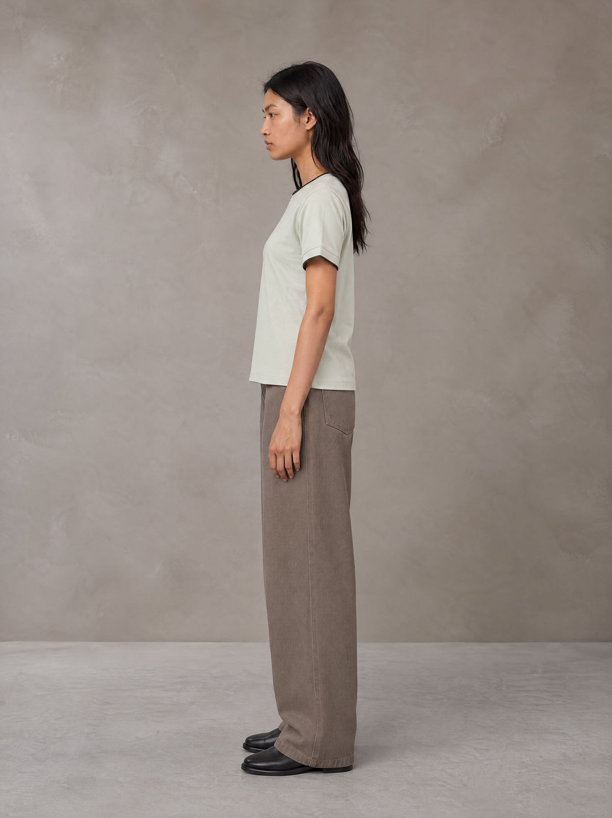 Model wearing SM Sunwash T-shirt in Moon Mist, side view.