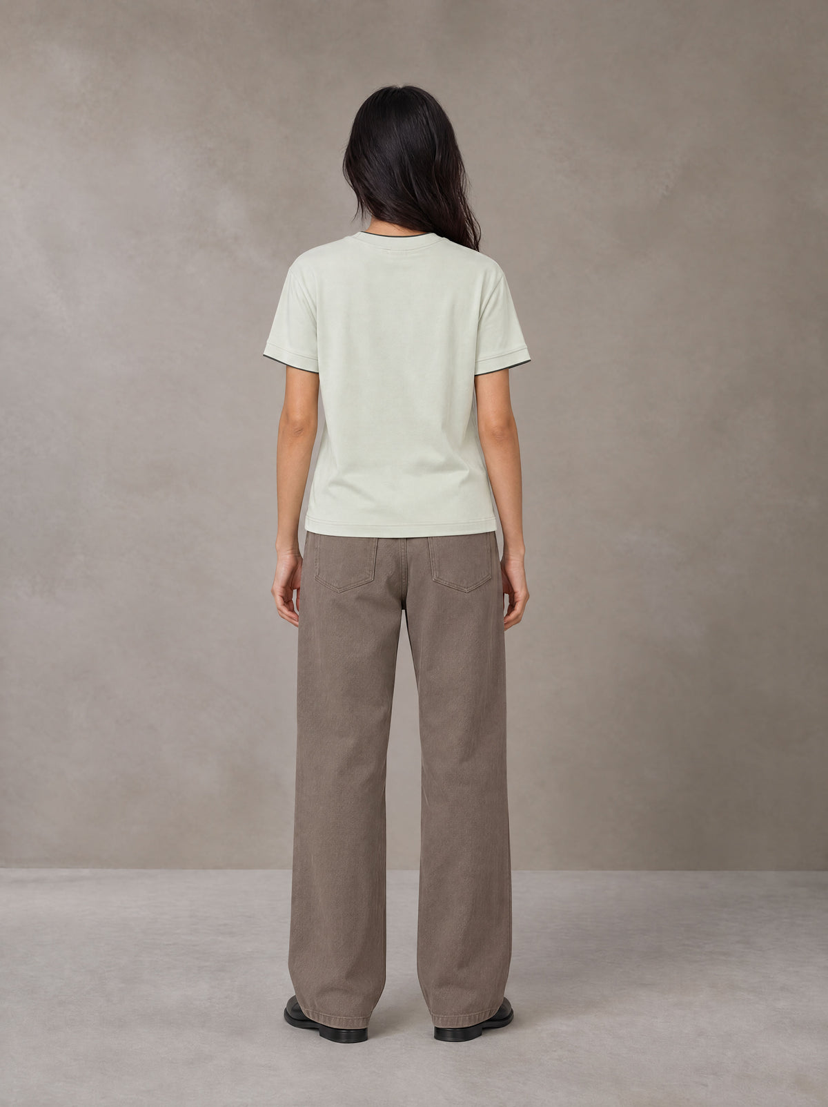 Model wearing SM Sunwash T-shirt in Moon Mist, rear view.