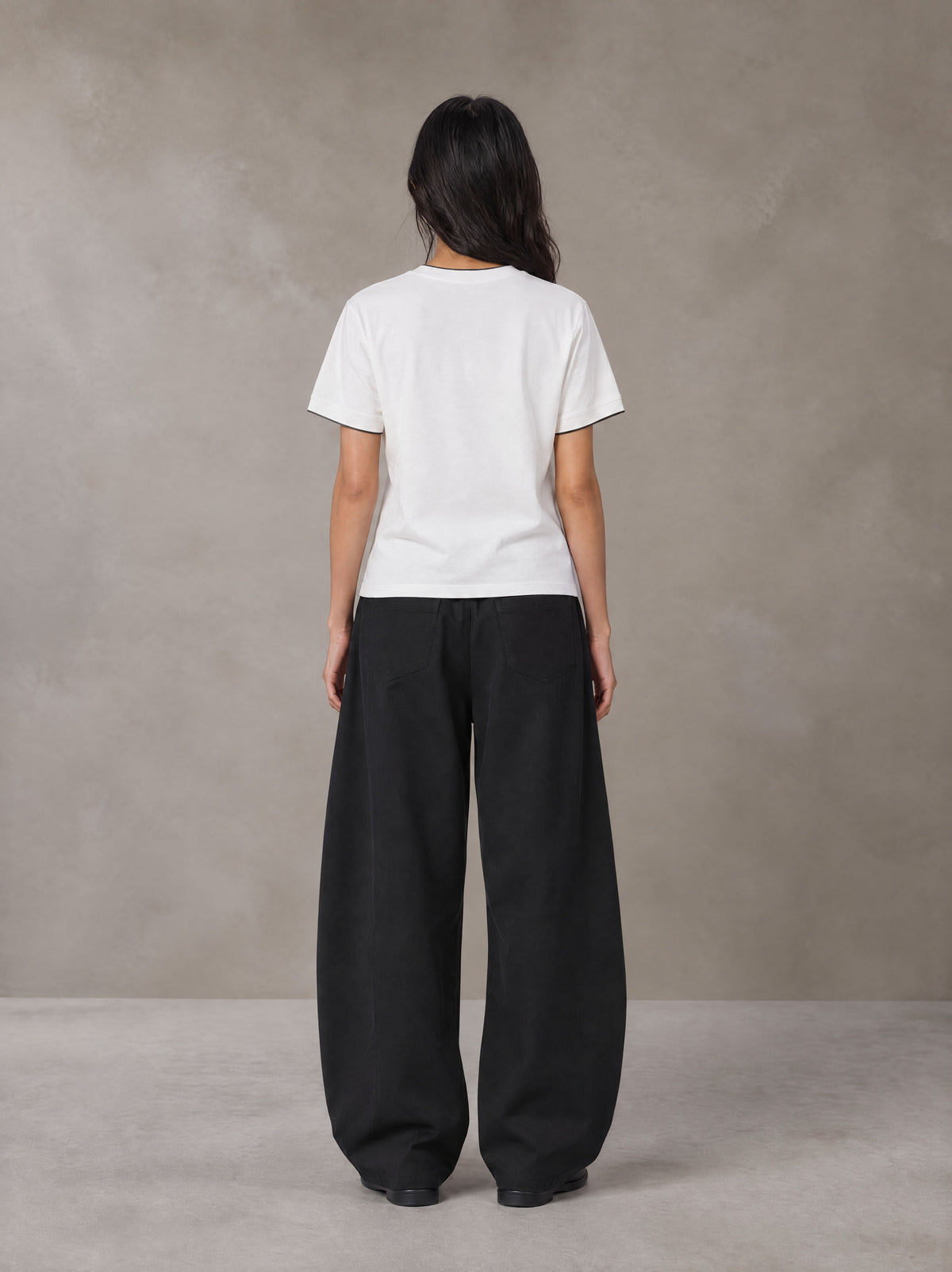 Model wearing SM Sunwash T-shirt in Lucent White, rear view.