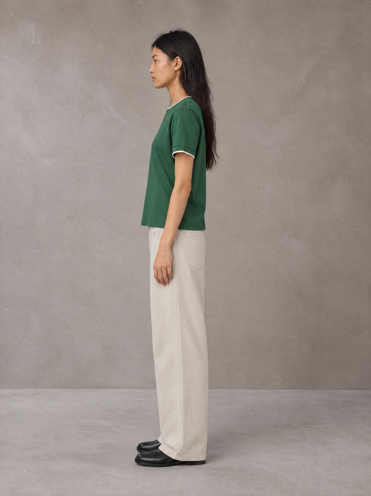 Model wearing SM Sunwash T-shirt in Dark Spring Green, side view.
