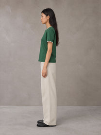 Model wearing SM Sunwash T-shirt in Dark Spring Green, side view.