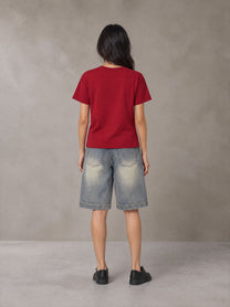 Model wearing SM Sunwash T-shirt in Deep Carmine, rear view.