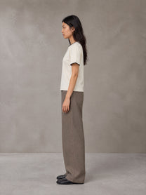 Model wearing SM Sunwash T-shirt in Oat Grey, side view.