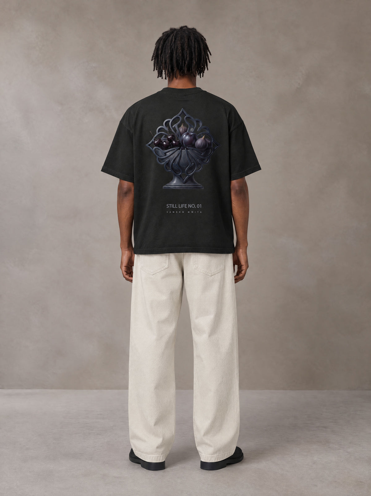 Model wearing SM Still Life NO.01 T-shirt in Midnight Black, rear view.