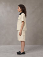 Model wearing SM Eternal Fleur Shirt in Pavlova with SM Eternal Fleur Utility Shorts in Pavlova, side view.