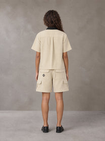 Model wearing SM Eternal Fleur Shirt in Pavlova with SM Eternal Fleur Utility Shorts in Pavlova, rear view.